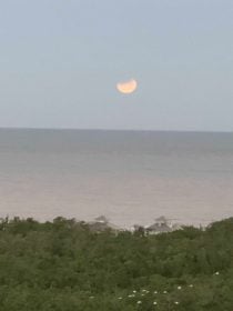 a view across the sea of a blue moon eclipse